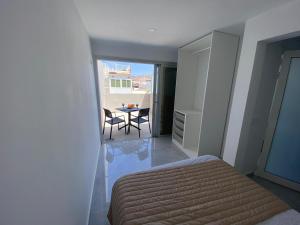 a bedroom with a bed and a table with chairs at Alaram Holidays House by Villas Rivero in Arguineguín