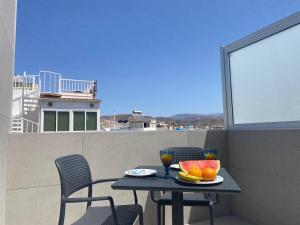 a table with a bowl of fruit on a balcony at Alaram Holidays House by Villas Rivero in Arguineguín +32 photos