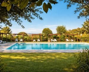 a swimming pool in a yard with chairs around it at Agriturismo Il Querciolo in Grosseto