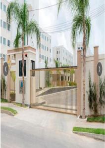 a gate in front of a building with palm trees at Apartamento no Antares in Maceió