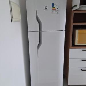 a white refrigerator in a kitchen next to a microwave at Apartamento no Antares in Maceió