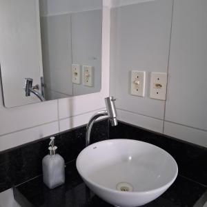 a white sink in a bathroom with a mirror at Apartamento no Antares in Maceió +11 photos