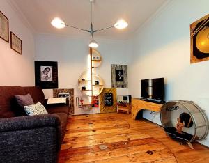 a living room with a couch and a wooden floor at Casa 40th-Music Wood House in Óbidos