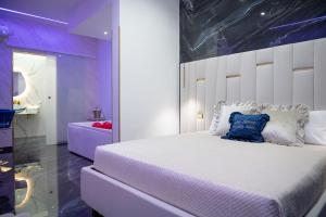 a bedroom with a large white bed with a blue pillow at OLD STREET Luxury suite in Avola