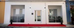 a white building with a red rug in front at OLD STREET Luxury suite in Avola
