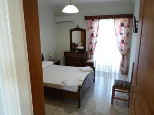 a bedroom with a bed and a mirror and a window at Hotel Villa Basil in Tsilivi