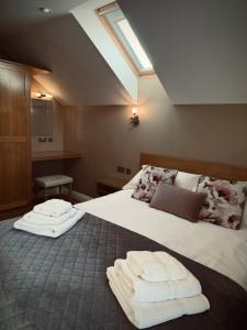 a bedroom with a bed with two towels on it at Middleton Cottages in Yarm +111 photos