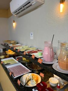 a buffet line with plates of food and drinks at Hotel GranDourados in Dourados
