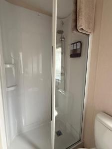 a shower with a glass door in a bathroom at Snug on the Teviot in Hawick