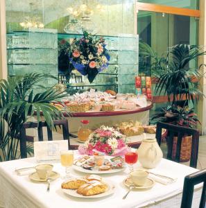 リミニにあるACasaMia WelcHome Hotelの食べ物と飲み物の盛り合わせが付いたテーブル