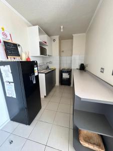 a kitchen with a black refrigerator and a counter at Edificio león Gallo in Temuco