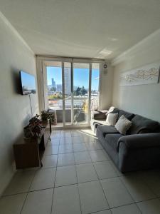 a living room with a couch and a large window at Edificio león Gallo in Temuco