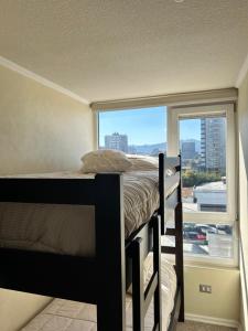 a bedroom with a bunk bed and a window at Edificio león Gallo in Temuco