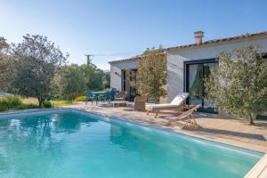 a house with a swimming pool in front of a house at Villa Ena in Figari