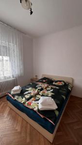 a bedroom with a bed with clothes on it at Apartman Ládi in Veľký Meder
