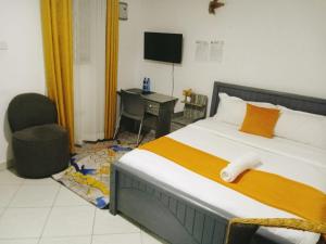 a bedroom with a bed with a chair and a desk at Shelvic Resort Ruiru in Ruiru