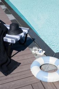 a swimming pool with a hat and a chaise lounge next to a pool at Domki w Białce WOODHOUSE- Twój górski azyl przy stoku in Białka Tatrzańska +96 photos