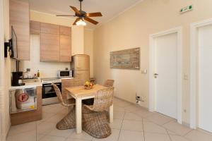 a kitchen with a table with chairs and a ceiling fan at Iliodysi Houses in Methoni