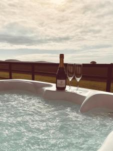 a bottle of wine and two wine glasses in a hot tub at Middleton Cottages in Yarm
