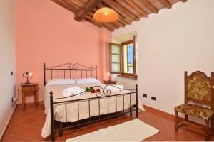 a bedroom with a bed and a chair at Casa Sofi - Happy Rentals in Monticiano