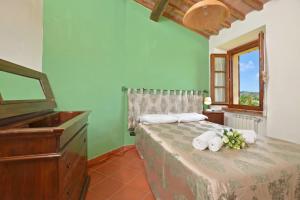 a bedroom with a bed with a dresser and a piano at Casa Sofi - Happy Rentals in Monticiano