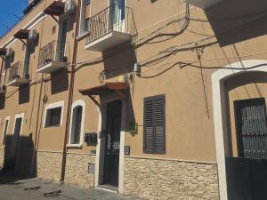 a brown building with a door and a balcony at Golden house sicily in Catania