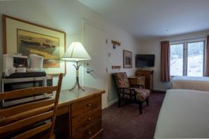 a hotel room with a bed and a desk with a lamp at Cahilty #211 home in Sun Peaks