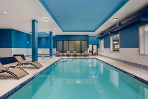a pool in a hotel with chairs and tables at Hampton Inn by Hilton Kamloops in Kamloops