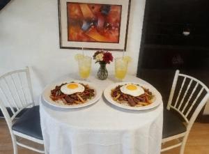 two plates of food on a table with eggs on it at Casona Kolivri in Arequipa