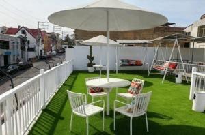 a patio with a table and chairs and an umbrella at Casona Kolivri in Arequipa