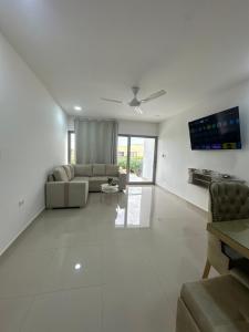 a living room with couches and a flat screen tv at Apartamento completo cerca del centro in Montería