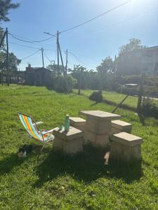 a picnic table and a chair with a drink on it at Barrio La Victoria in Ezeiza