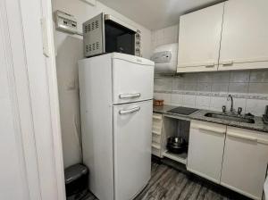 a white refrigerator in a small kitchen with a sink at Loft plaza España in Mendoza
