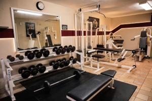 a fitness room with a mirror and weights at Business Hotel & Suites María Bonita in Ciudad Juárez