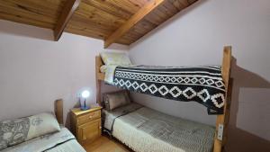 a bedroom with two bunk beds and a table with a candle at La Colina in Río Mayo