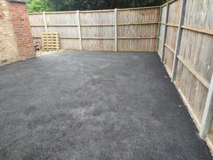 a parking lot next to a wooden fence at Luxury 4BR Bungalow in Hackbridge