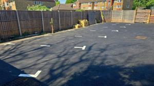 an empty parking lot with a fence and buildings at Luxury 4BR Bungalow in Hackbridge +3 photos