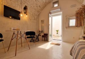 a room with a bed and a table and chairs at CASA FLAMÌ 2 in Ostuni