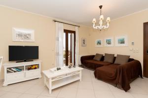 a living room with a couch and a tv at Iliodysi Houses in Methoni +32 photos