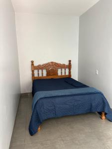 a bedroom with a bed with a blue comforter at Conforto e praticidade em um só local in Rio Verde