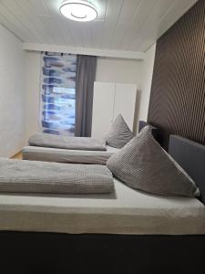 two beds in a room with a window at Ferienwohnung Gabry in Saarlouis