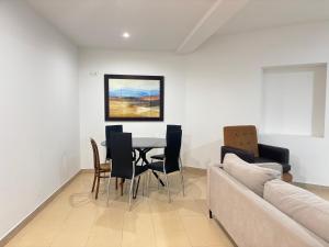 a living room with a table and chairs and a couch at Desconectaengalicia Carlos Casas Playa Silgar in Sanxenxo