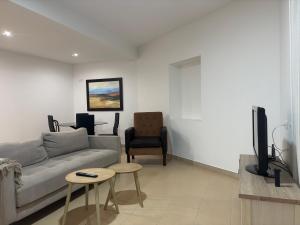 a living room with a couch and a tv at Desconectaengalicia Carlos Casas Playa Silgar in Sanxenxo