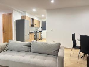 a living room with a couch and a kitchen at Desconectaengalicia Carlos Casas Playa Silgar in Sanxenxo