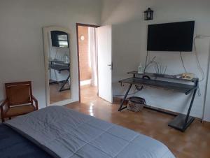 a bedroom with a bed and a flat screen tv at Rincon Del Colibri in Reyes
