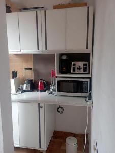 a kitchen with white cabinets and a microwave at Rincon Del Colibri in Reyes
