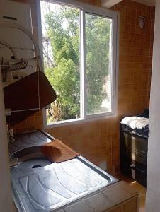 a kitchen with a sink and two windows at Rincon Del Colibri in Reyes +2 photos