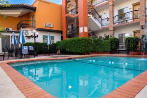 a swimming pool in front of a building at Business Hotel & Suites María Bonita in Ciudad Juárez