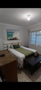 a bedroom with a large bed and a window at Maselli Guesthouse in Howick