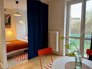a room with a bed and a table and a window at Lovely Jubbly Apartment in Krakow